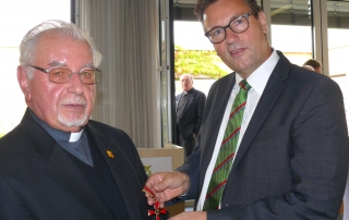 Pater Schmidpeter bekommt von Minister Hauk das Bundesverdienstkreuz überreicht